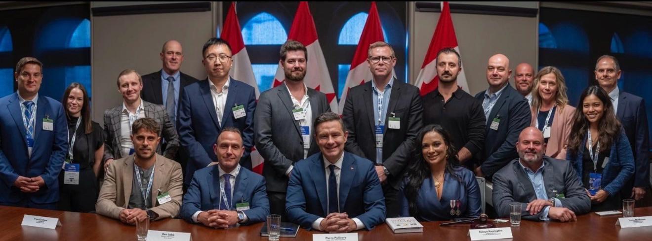 Group photo of Canadian MPs and Bitcoin industry leaders at Bitcoin on the Hill 2025, with Pierre Poilievre seated center, Canadian flags in the background.