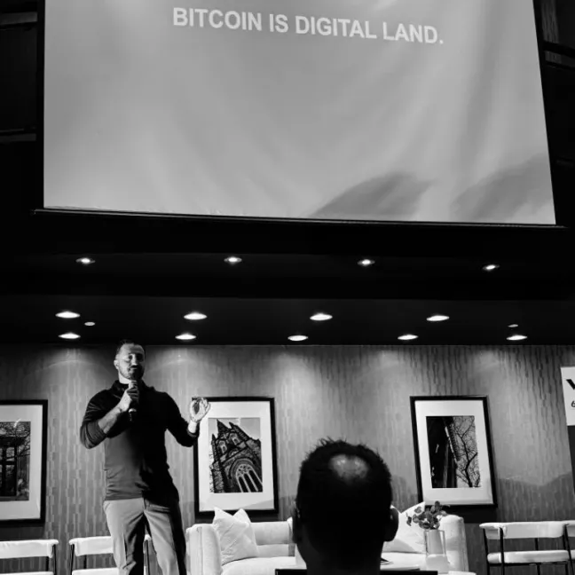 Speaker presenting about Bitcoin as digital land to an audience