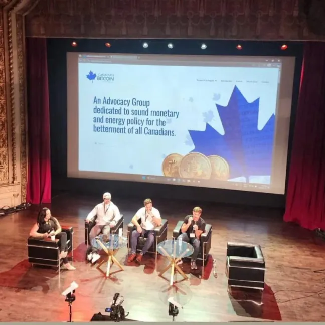 Panelists on stage at the Canadian Bitcoin Conference 2025 in Montreal, seated in front of a large screen promoting Bitcoin advocacy for Canada.